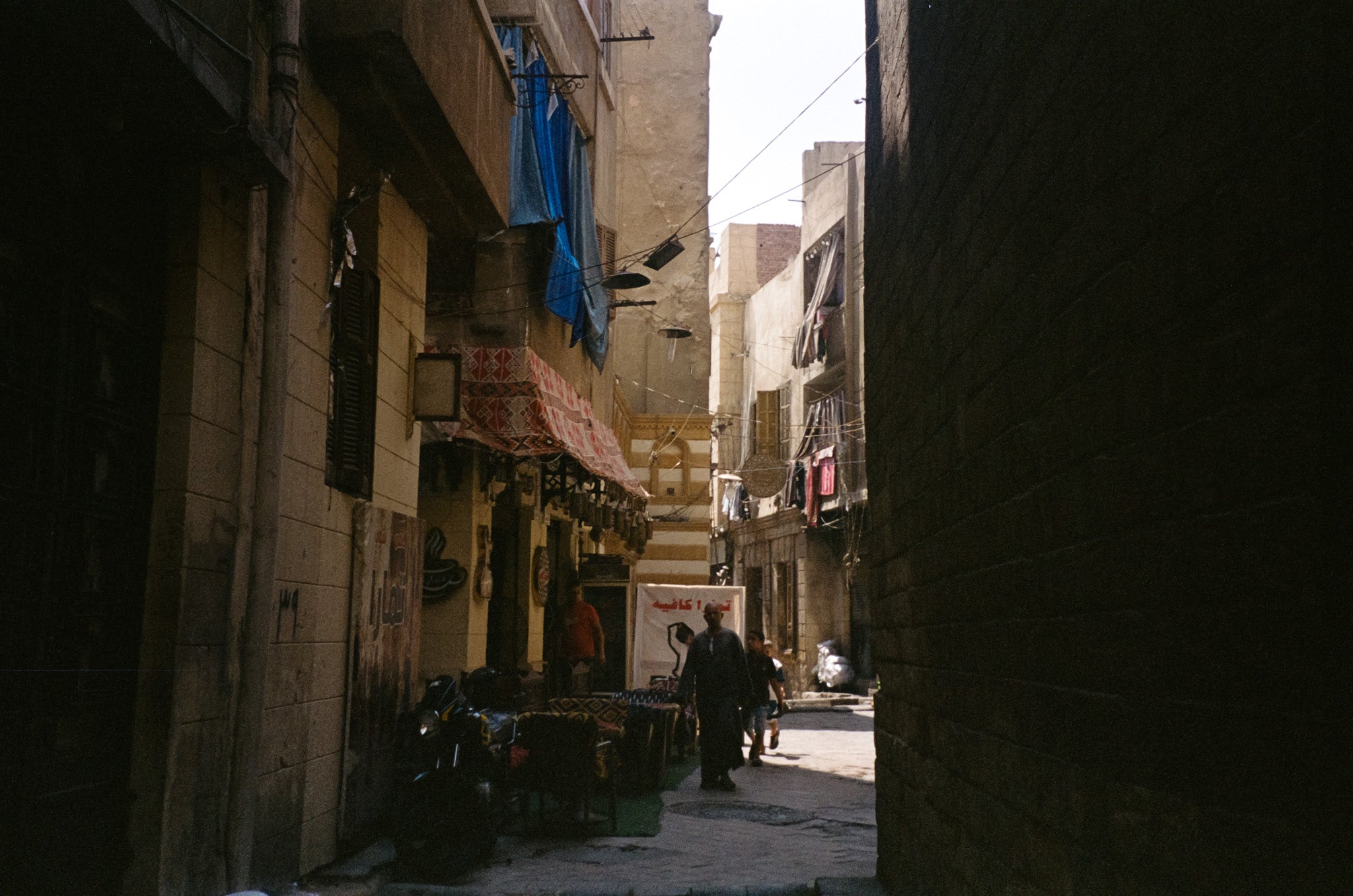 Dark alleyway with Arabic signs and laundry overhead in Downtown Cairo, Egypt — film photography by Loud Etudes