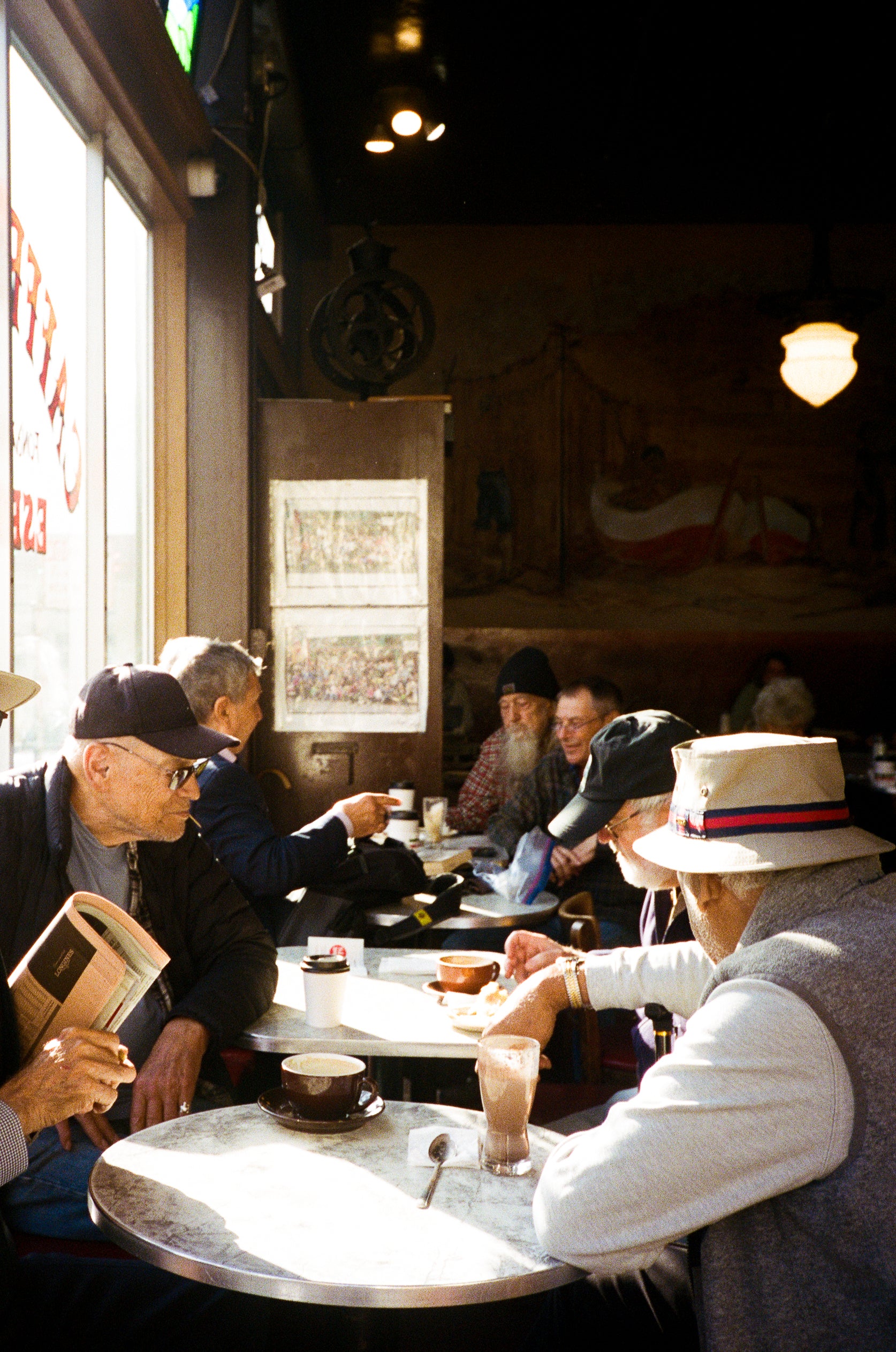 People sitting at a table in the restaurant with vintage decor — film photography by Loud Etudes 